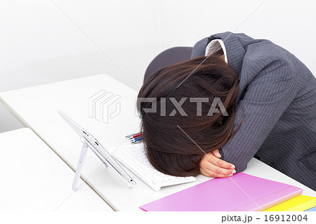 女性 オフィスレディ ビジネス 疲労 うたた寝 居眠り 机に突っ伏す 休憩 手 パーツ スーツの写真素材