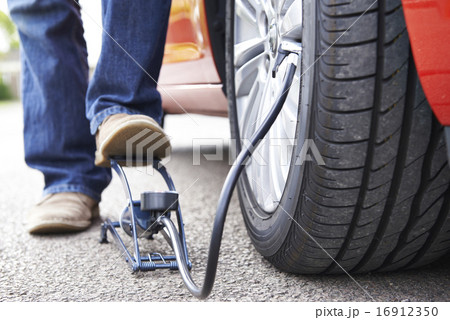 Close Up Of Man Inflating Car Tyre With Foot Pump 16912350