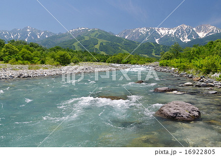 長野県白馬村 姫川上流の松川の清流と初夏の白馬三山遠望の写真素材