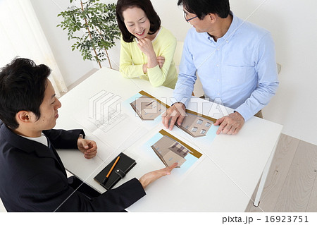 ミドル夫婦に説明するビジネスマン 16923751