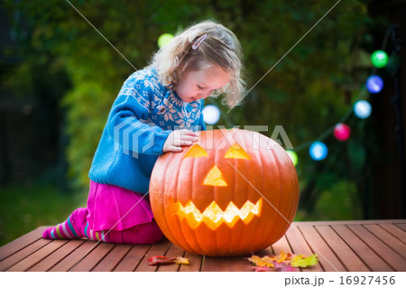 Little girl carving pumpkin at Halloween Little girl carving pumpkin at Halloween 16927456