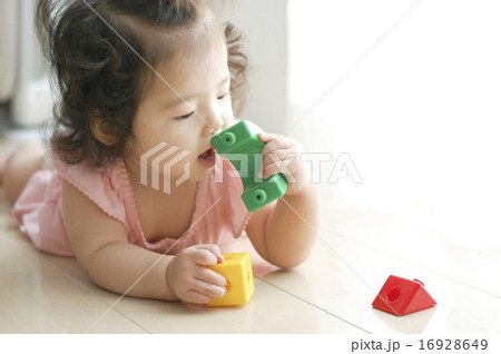 おもちゃを口に入れる赤ちゃん 16928649