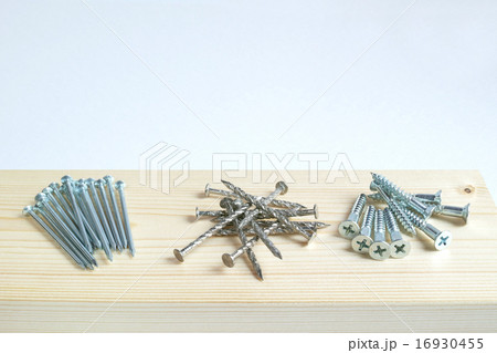 木の板の上に載せた丸釘とスクリュー釘と木ネジ 16930455