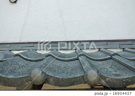 屋根の簡単リホーム 塗装と補修前の庇屋根瓦のダメージ 正面横位置の写真素材