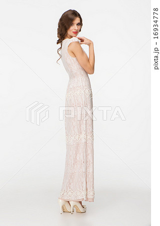 Back shot of young woman with curly hair wearing dress 16934778