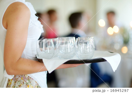 Waitress holding a dish of glasses 16945297