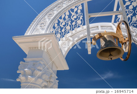 Bell hanging in arch over blue sky background 16945714