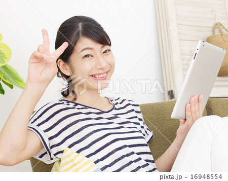 タブレットを使う女性 ピースサイン タブレットを使う女性 ピースサイン 16948554