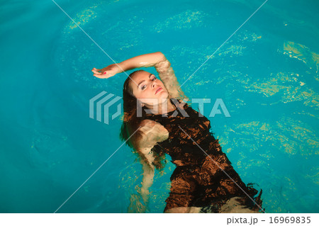 Woman floating relaxing in swimming pool water. Woman floating relaxing in swimming pool water. 16969835