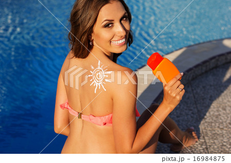 Sun shape drawing from sunscreen lotion on girls shoulder 16984875