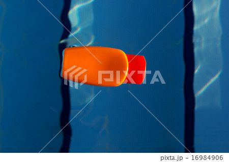 Jar with sunscreen uv lotion in water of swimming pool 16984906