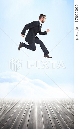 Composite image of geeky young businessman running mid air 17002009