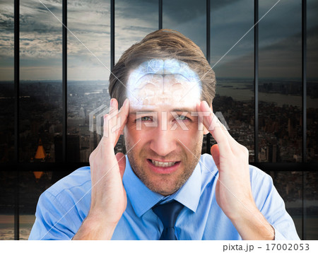 Composite image of young businessman with severe headache 17002053