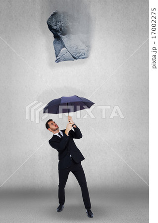 Composite image of businessman standing under black umbrella Composite image of businessman standing under black umbrella 17002275