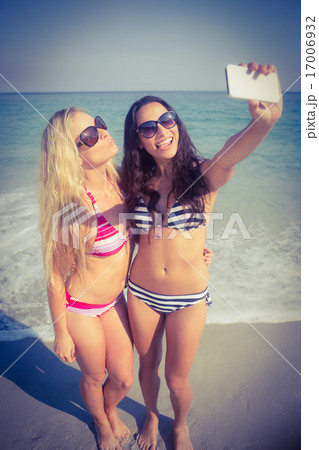 two friends in swimsuits taking a selfie two friends in swimsuits taking a selfie 17006932