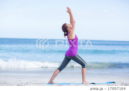 Brunette doing yoga on exercise mat 17007164