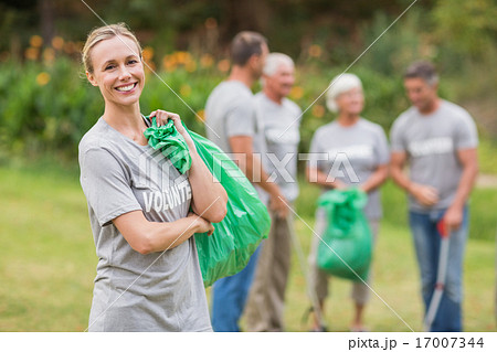 Happy volunteer collecting rubbish 17007344