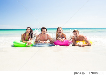 Happy friends lying on inflatable mattress above the water Happy friends lying on inflatable mattress above the water 17008369