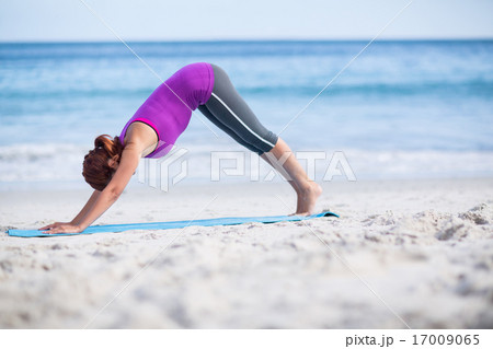 Brunette doing yoga on exercise mat 17009065