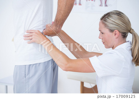 Doctor examining her patient back 17009125
