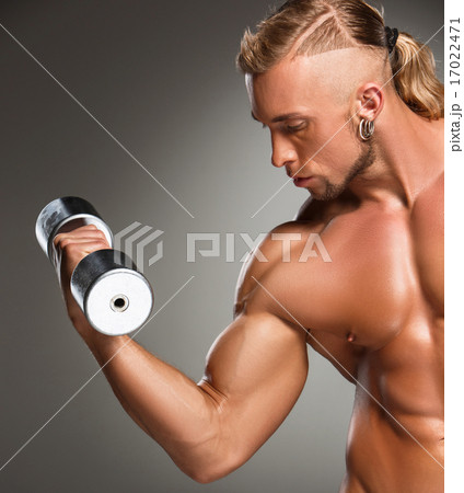 Closeup of a handsome power athletic man bodybuilder doing exercises with dumbbell Closeup of a handsome power athletic man bodybuilder doing exercises with dumbbell 17022471