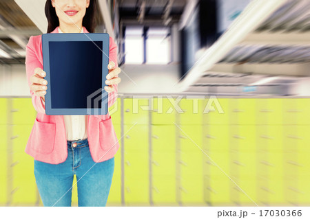 Composite image of elegant brunette using tablet 17030366