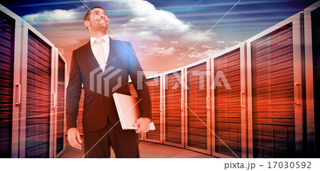 Composite image of businessman looking up holding laptop 17030592