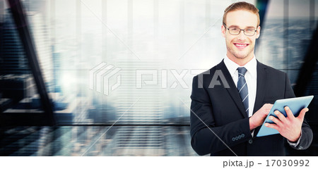 Composite image of happy businessman using his tablet pc 17030992
