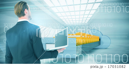 Composite image of businessman looking up holding laptop 17031082
