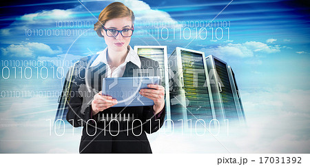 Composite image of redhead businesswoman using her tablet pc 17031392