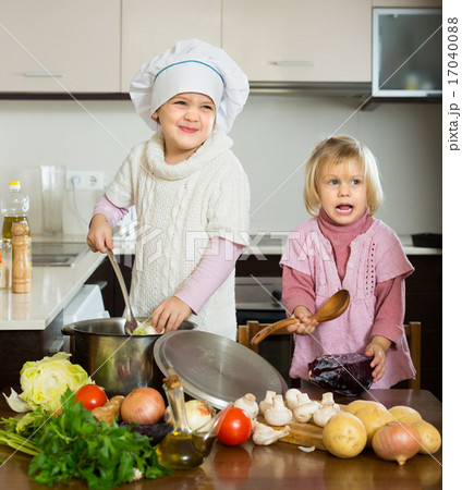 Two little sisters learning how to cook 17040088