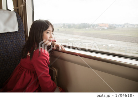 Little asian girl looking through window. 17046187