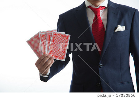 トランプのカードを持つビジネスマンの写真素材