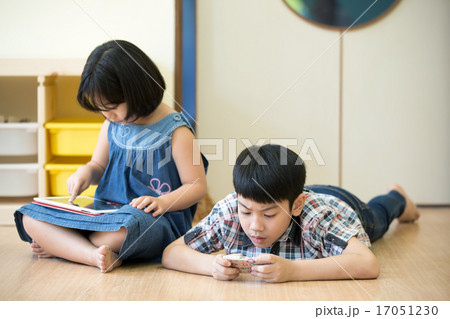 Little Asian boy and girl are playing together with a computer t Little Asian boy and girl are playing together with a computer t 17051230
