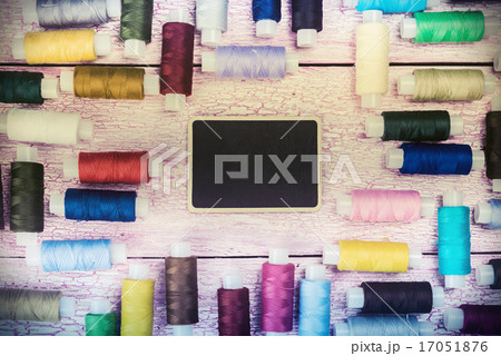 bobbins with colorful threads on old wooden table bobbins with colorful threads on old wooden table 17051876