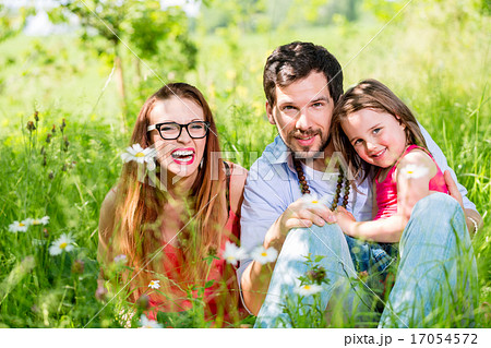 Family sitting on meadow giving their kid protection Family sitting on meadow giving their kid protection 17054572