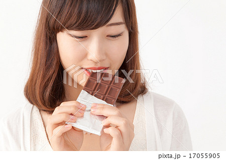 チョコレートを食べる若い女性の写真素材