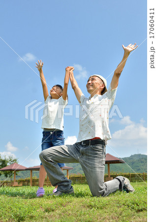 青空でバンザイする親子（夏） 17060411