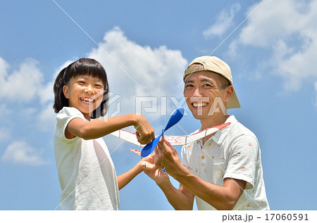 青空に模型飛行機を飛ばす親子(夏) 17060591