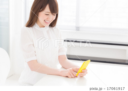 部屋でスマホを見る女性 部屋でスマホを見る女性 17061917