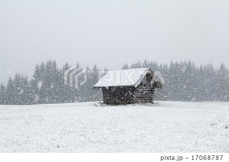 heavy snowstorm over old wooden hut 17068787