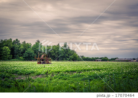 Water pump on a green field in dark weather Water pump on a green field in dark weather 17070464