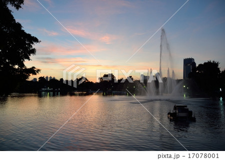 バンコク・夜明けのルンピニ公園の噴水とビル群 17078001
