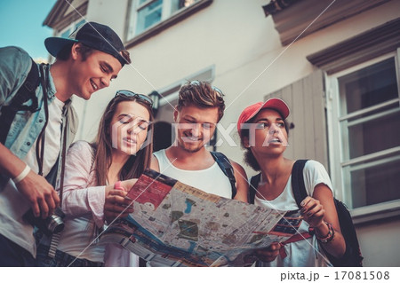 Multiracial friends tourists with map in an old city Multiracial friends tourists with map in an old city 17081508