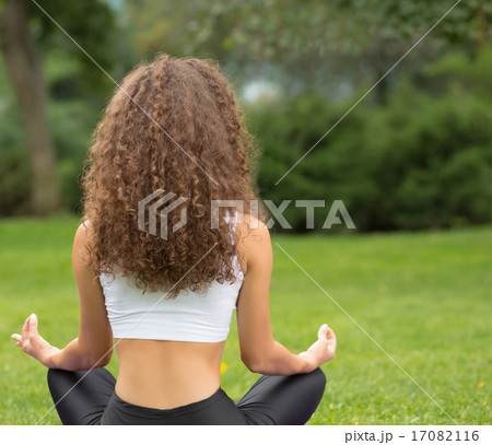 Pretty woman sitting back doing yoga meditation Pretty woman sitting back doing yoga meditation 17082116