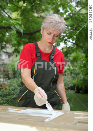 Female worker restoring old wooden door Female worker restoring old wooden door 17085260