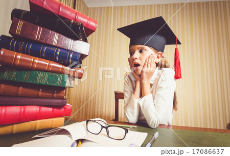 amazed smart girl looking at big heap of books amazed smart girl looking at big heap of books 17086637