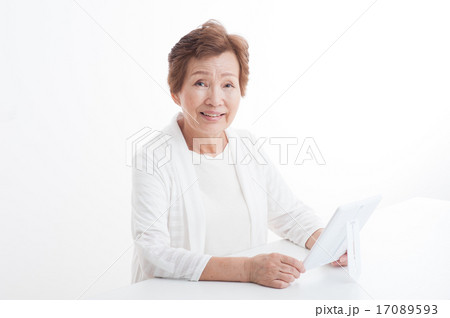 鏡で自分の顔を見ているシニアの女性 17089593