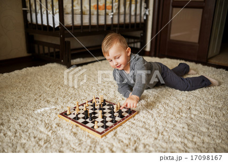 little boy plays chess lying on floor little boy plays chess lying on floor 17098167