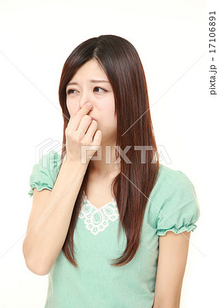 鼻をつまむ女性の写真素材
